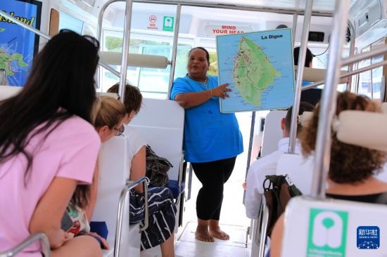 3月15日，一名導(dǎo)游在游艇上為游客介紹塞舌爾拉迪格島。新華社記者 董江輝 攝