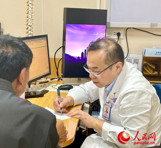 路桂軍接診時為患者寫下用藥提示。人民網(wǎng)記者 金慧慧攝