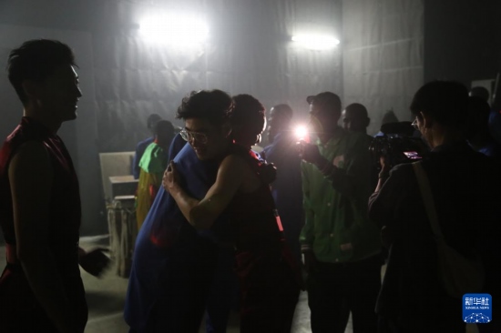 4月10日，在塞內加爾首都達喀爾的國家大劇院，中央音樂學院進擊打擊樂團成員與塞內加爾杜杜·恩迪亞耶·羅斯打擊樂團成員在演出后臺擁抱。新華社記者 司源 攝