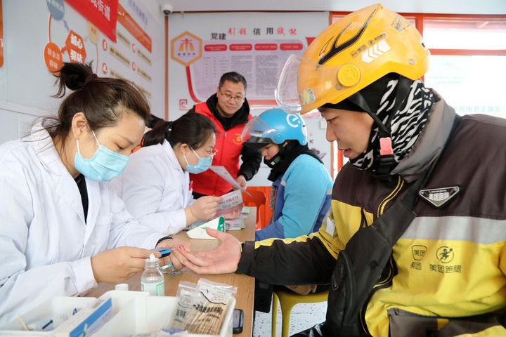 2025年3月5日，志愿者在山東省棗莊市市中區(qū)一工會驛站為外賣員免費測量血糖。新華社發(fā)（王海楠攝）