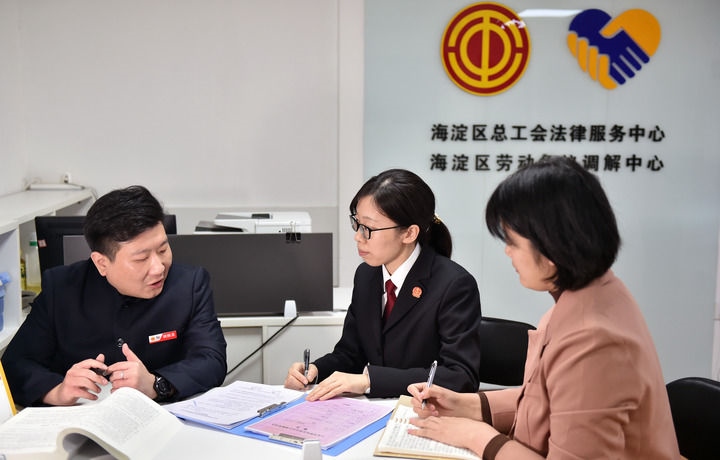 2025年3月6日，在北京市海淀區(qū)總工會勞動爭議調(diào)解中心，海淀區(qū)人民法院法官王琰（中）與該中心工作人員就糾紛化解情況進行溝通。新華社記者 趙婷婷 攝