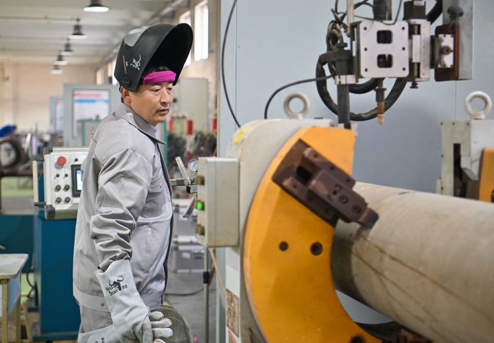 在中石化第四建設有限公司工匠學院，全國人大代表、中石化第四建設有限公司工匠學院焊接教練張振連操作自動焊機（2025年2月21日攝）。新華社記者 孫凡越 攝