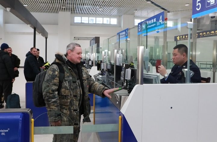 2024年12月10日，在黑河公路口岸旅檢大廳，黑河出入境邊防檢查站民警為首班次客車(chē)入境旅客辦理邊檢通關(guān)手續(xù)。當(dāng)日，中國(guó)黑河公路口岸—俄羅斯卡尼庫(kù)爾干公路口岸旅客運(yùn)輸正式開(kāi)通。新華社發(fā)（劉松攝）