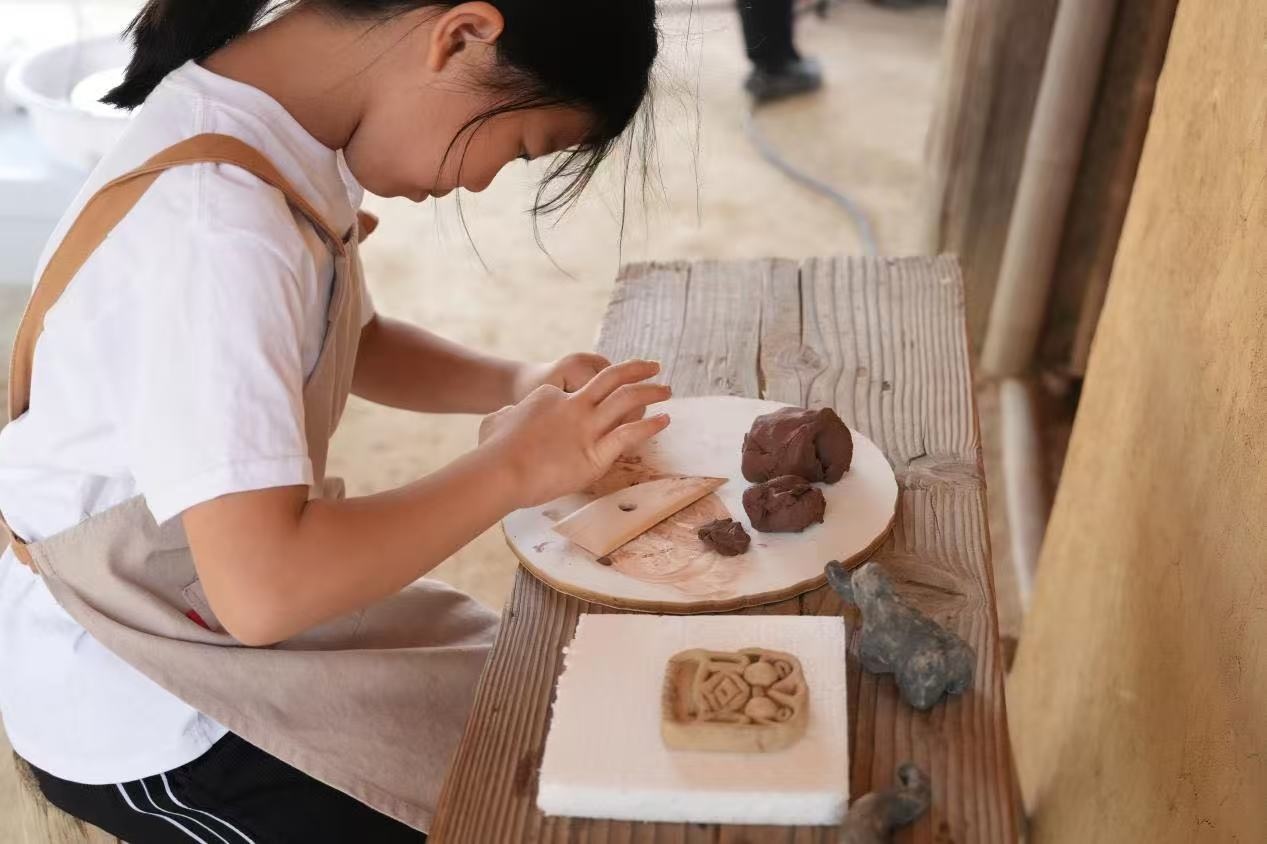游客制作良渚特色陶藝品。良渚博物院供圖