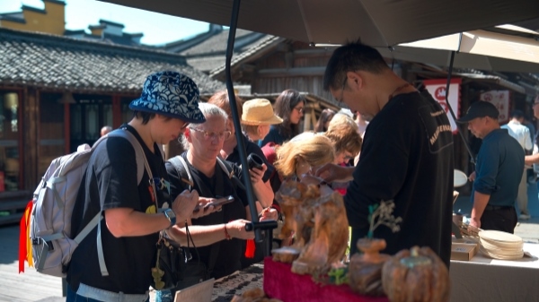 “五一”期間，游客正在烏鎮(zhèn)“水鄉(xiāng)碼頭”挑選購買文創(chuàng)產(chǎn)品。受訪者供圖