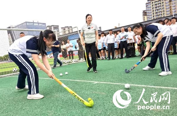 陳朝霞（中）指導(dǎo)學(xué)生體驗(yàn)曲棍球。 人民網(wǎng)記者 楊磊攝