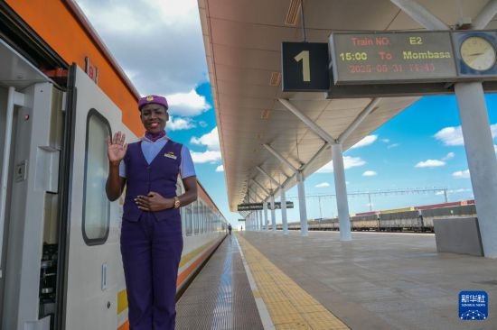 5月31日，在蒙內(nèi)鐵路內(nèi)羅畢站，一名乘務(wù)員在即將開往蒙巴薩的E2次列車旁等候乘客。新華社記者 楊光 攝