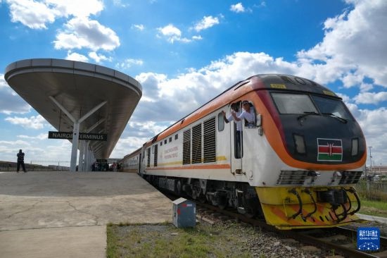 5月31日，在蒙內(nèi)鐵路內(nèi)羅畢站，機(jī)車駕駛員蔣立平（右）和博爾在即將開往蒙巴薩的E2次列車上揮手致意。新華社記者 楊光 攝