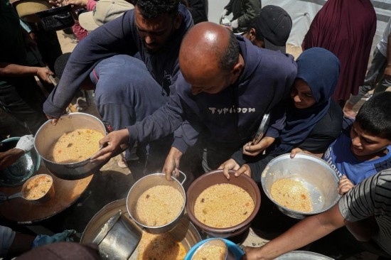 5月28日，人們?cè)诩由吵俏鞑康纳程犭y民營(yíng)領(lǐng)取救助食物。新華社發(fā)（里澤克·阿卜杜勒賈瓦德攝）
