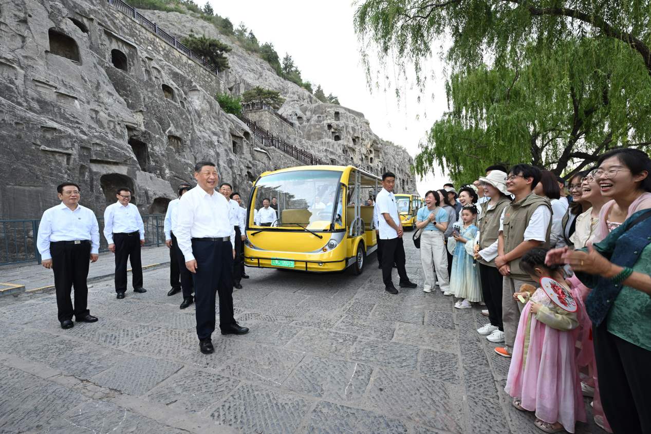 5月19日，習近平在洛陽龍門石窟考察時，同游客親切交流。